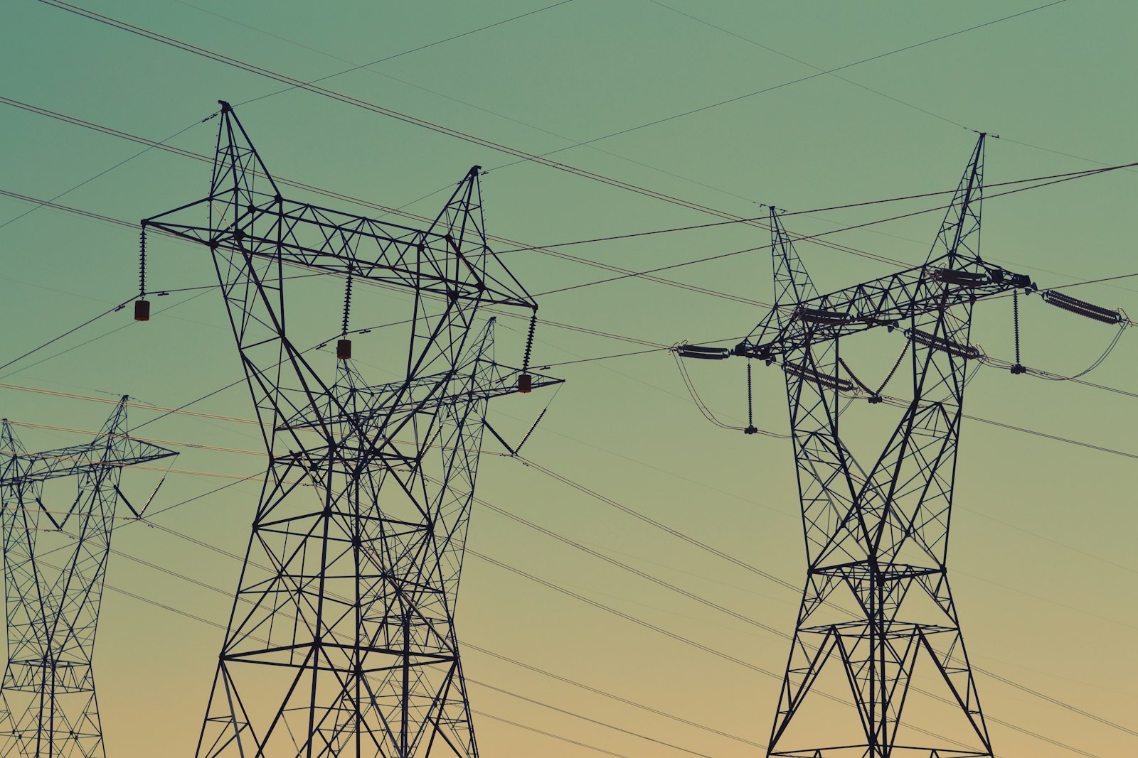 High-voltage transmission towers against a dusk sky
