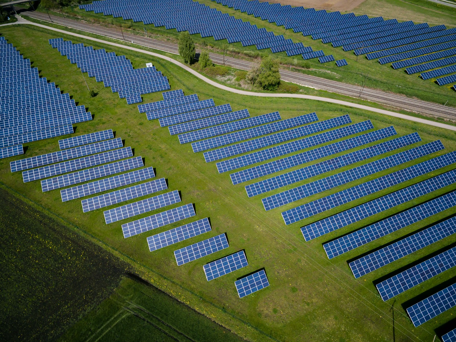 Aerial view of a ground-mount solar farm on green farmland